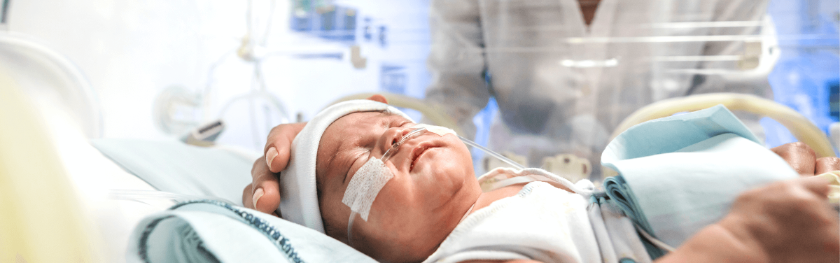 A baby in an incubator in the NICU.