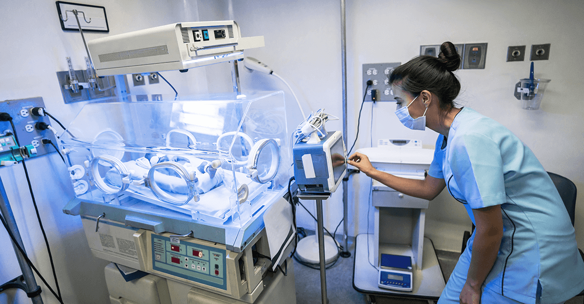 A nurse looking at a monitor in the NICU.