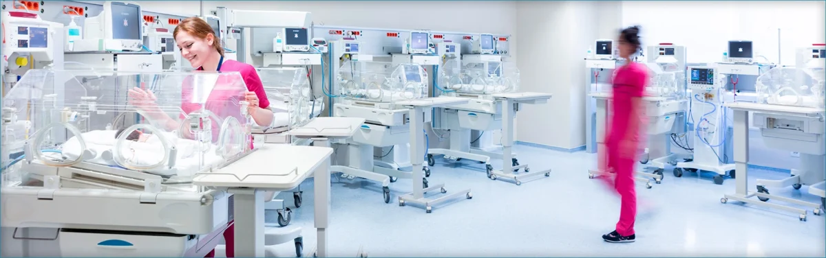 Two NICU nurses taking care of infants.