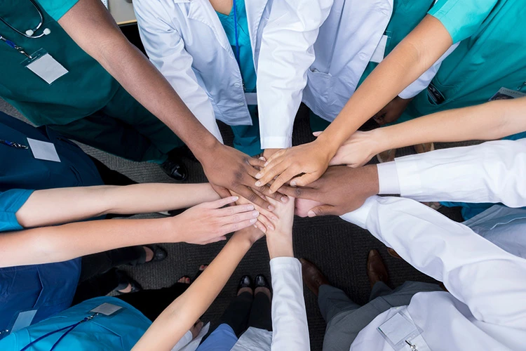 image of a collection of hands in the middle of a circle of HCPs